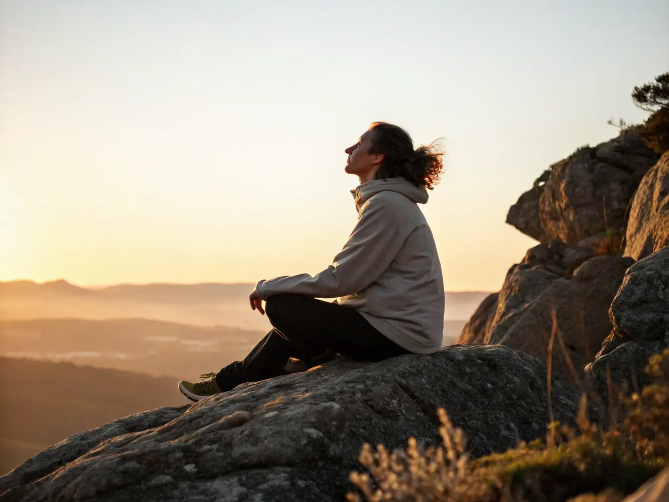 A serene image depicting a person meditating outdoors at sunrise, symbolizing increased mindfulness and inner peace achieved through InnerBalanceHub.